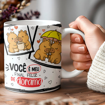 Mug with cartoon design and text held by a hand on a wooden surface