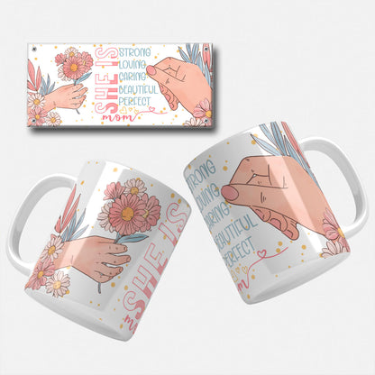 Mothers day mug wrap png. Charming mug wrap with a hand holding flowers and the text 'She is Strong, Loving, Caring, Beautiful, Perfect Mom' on a black background with floral elements.